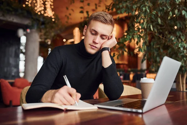 Başarılı Genç Adam Üzerinde Dizüstü Bilgisayarı Olan Bir Kafede Oturuyor — Stok fotoğraf