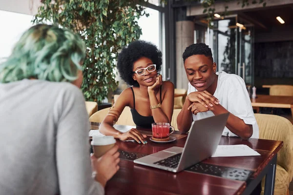 Alternatif saçlı, yeşil saçlı, çok ırklı bir grup insan kapalı alanda birlikte çalışıyorlar..