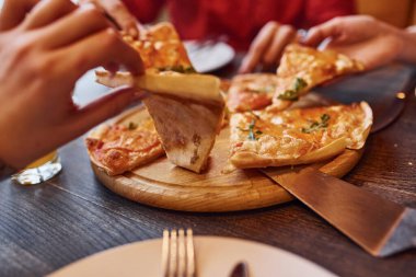 Kapalı alanda pizza yiyen ve alan insanları yakından izleyin..