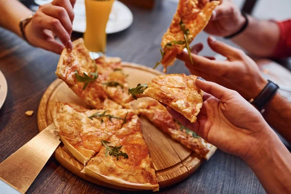 Kapalı alanda pizza yiyen ve alan insanları yakından izleyin..