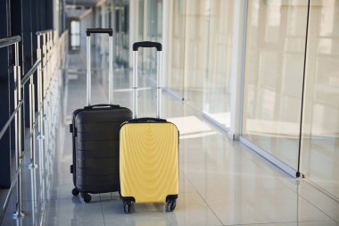 Black and white suitcases in airport hall at daytime.
