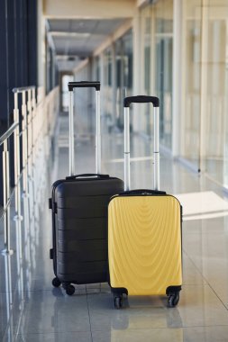 Black and white suitcases in airport hall at daytime.