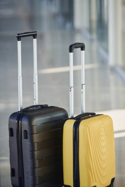 Black and white suitcases in airport hall at daytime.