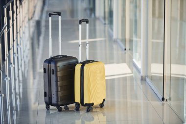 Black and white suitcases in airport hall at daytime.