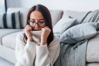 Young beautiful woman in glasses sitting at home alone.