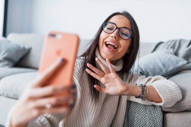 Sohbet ediyorduk. Gözlüklü genç ve güzel bir kadın evde tek başına oturuyor. Elinde telefon var..