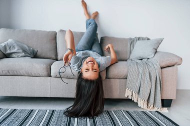 Young beautiful woman in casual clothes lying down on the bed and have fun at home alone.