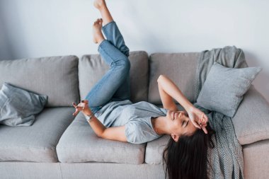 Young beautiful woman in casual clothes lying down at home alone.