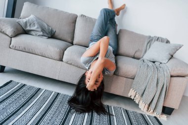 Young beautiful woman in casual clothes lying down on the bed and have fun at home alone.