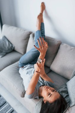 Young beautiful woman in casual clothes lying down at home alone.