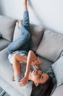 Young beautiful woman in casual clothes lying down at home alone.