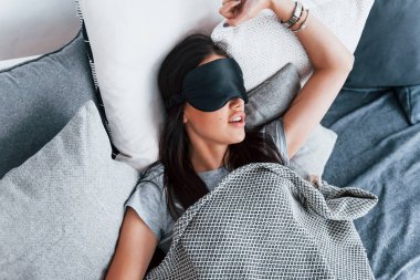 Genç ve güzel bir kadın evde tek başına yatağa uzanıyor ve uyuyor..