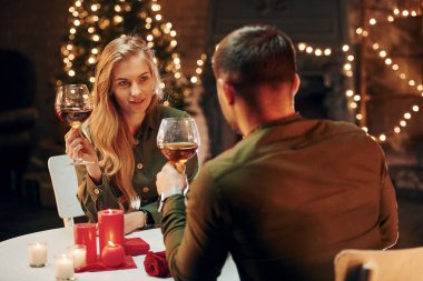 Aktif konuşma. Genç ve güzel çift evde romantik bir akşam yemeği yiyor..