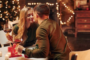 Birbirimizi öpüyoruz. Genç ve güzel çift evde romantik bir akşam yemeği yiyor..