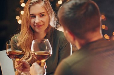 Şarap tadıyorum. Genç ve güzel çift evde romantik bir akşam yemeği yiyor..