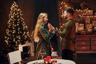 Ayakta ve dans ederek. Genç ve güzel çift evde romantik bir akşam yemeği yiyor..