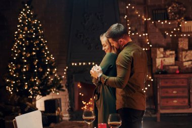 Ayakta ve dans ederek. Genç ve güzel çift evde romantik bir akşam yemeği yiyor..