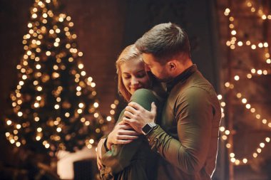 Ayakta durmak ve birbirimizi kucaklamak. Genç ve güzel çift evde romantik bir akşam yemeği yiyor..