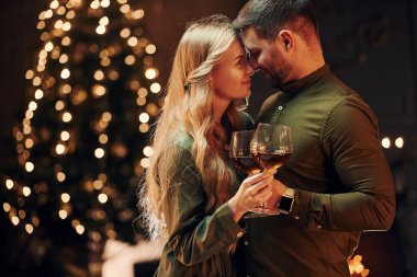 Ayakta durmak ve birbirimizi kucaklamak. Genç ve güzel çift evde romantik bir akşam yemeği yiyor..