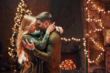 Ayakta durmak ve birbirimizi kucaklamak. Genç ve güzel çift evde romantik bir akşam yemeği yiyor..