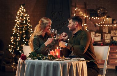 Şarap içiyormuş. Genç ve güzel çift evde romantik bir akşam yemeği yiyor..