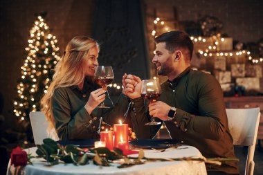 Şarap içiyormuş. Genç ve güzel çift evde romantik bir akşam yemeği yiyor..