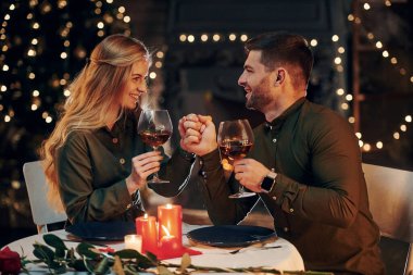 Şarap içiyormuş. Genç ve güzel çift evde romantik bir akşam yemeği yiyor..