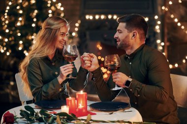 Şarap içiyormuş. Genç ve güzel çift evde romantik bir akşam yemeği yiyor..