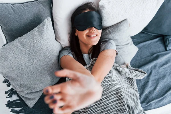 Genç ve güzel bir kadın evde tek başına yatağa uzanıyor ve uyuyor..