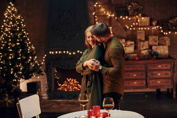 Ayakta ve dans ederek. Genç ve güzel çift evde romantik bir akşam yemeği yiyor..