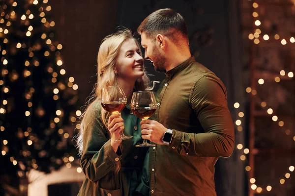 站在那里 拿着大杯葡萄酒 年轻貌美的夫妻在室内共进浪漫晚餐 — 图库照片