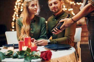 Garson ödeme bekliyor. Genç ve güzel çift evde romantik bir akşam yemeği yiyor..