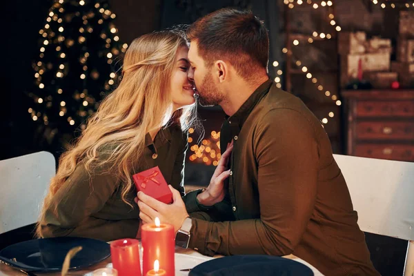 Adamın elinde hediye kutusu var. Evlenme teklifi yapar. Genç ve güzel çift evde romantik bir akşam yemeği yiyor..