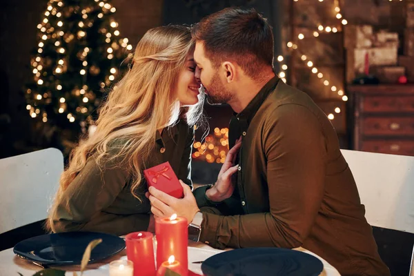 Adamın elinde hediye kutusu var. Evlenme teklifi yapar. Genç ve güzel çift evde romantik bir akşam yemeği yiyor..