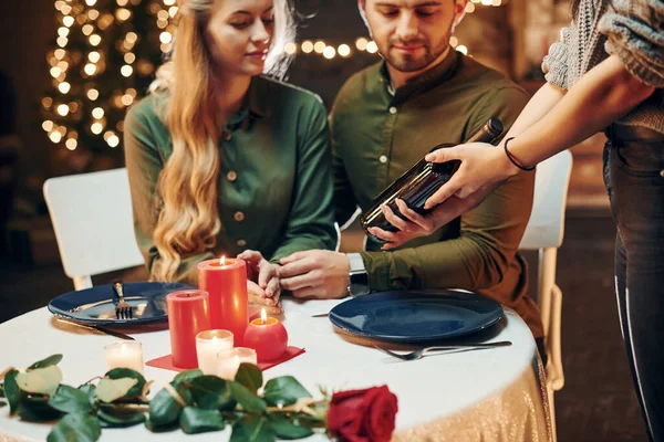 Garson ödeme bekliyor. Genç ve güzel çift evde romantik bir akşam yemeği yiyor..