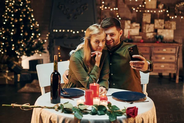 Telefon kullanarak selfie çekiyoruz. Genç ve güzel çift evde romantik bir akşam yemeği yiyor..