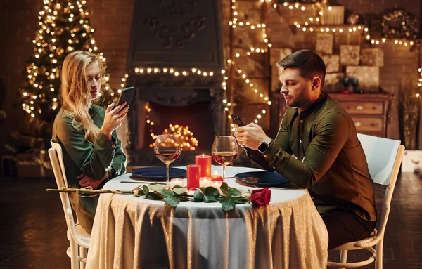 Sits Using Phone Young Lovely Couple Have Romantic Dinner Indoors — Fotografia de Stock