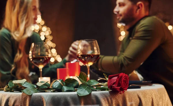 Ellerinden tutarak. Genç ve güzel çift evde romantik bir akşam yemeği yiyor..