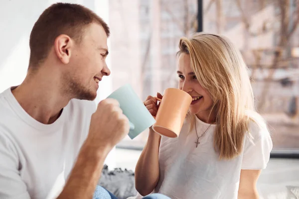 Young Lovely Couple Together Drinking Warm Tea Home Spending Weekend — стоковое фото