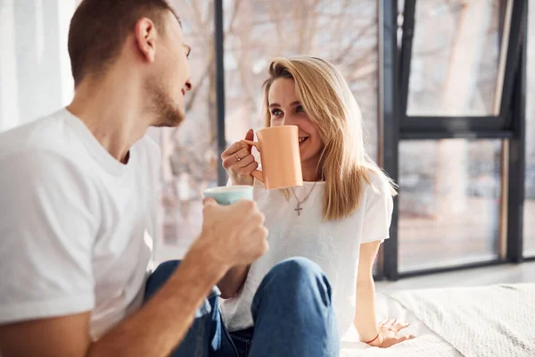 Young Lovely Couple Together Drinking Warm Tea Home Spending Weekend — стоковое фото