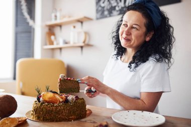 Torunuyla birlikte mutfakta taze diyet pasta yiyen yaşlı bir kadın..