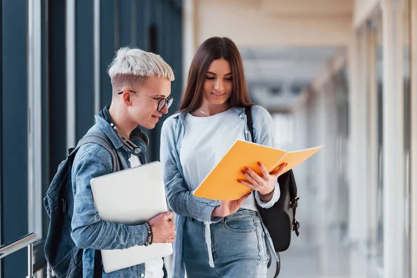 İki genç öğrenci bir üniversitenin koridorunda birlikteler..