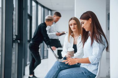 Bir grup başarılı genç takım ofiste birlikte çalışıyor. Belgeler ve dizüstü bilgisayarlarla birlikte..