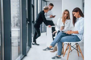 Bir grup başarılı genç takım ofiste birlikte çalışıyor. Belgeler ve dizüstü bilgisayarlarla birlikte..