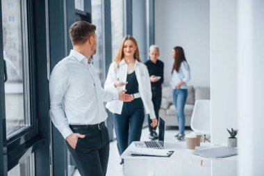 Ofiste birlikte çalışan ve iletişim kuran başarılı bir grup genç..