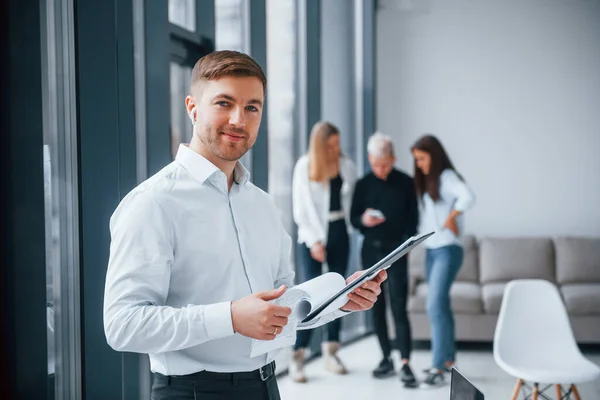 Man Formella Kläder Stående Med Dokument Framför Unga Framgångsrika Team — Stockfoto