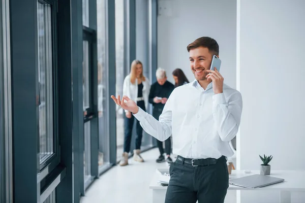 Man Formella Kläder Talar Telefon Och Står Framför Unga Framgångsrika — Stockfoto