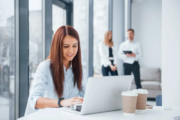 Kvinna Med Bärbar Dator Sitter Framför Grupp Unga Framgångsrika Team — Stockfoto