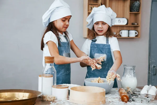 Δύο Κοριτσάκια Μπλε Στολή Σεφ Ετοιμάζουν Φαγητό Στην Κουζίνα — Φωτογραφία Αρχείου