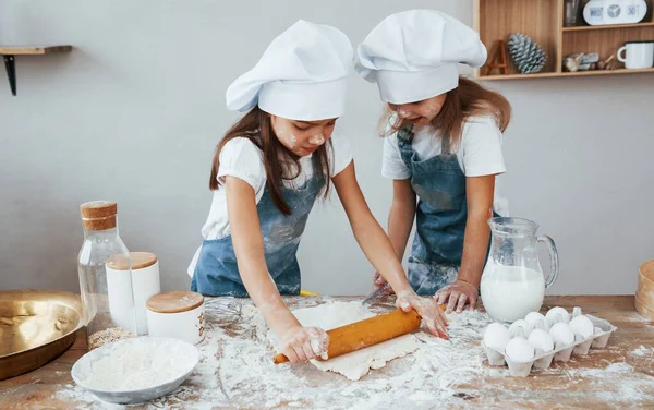 Two Little Girls Blue Chef Uniform Kneading Dough Kitchen — стоковое фото